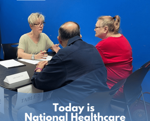Older couple, sitting down across an attorney, filling out their Health Care Power of Attorney.